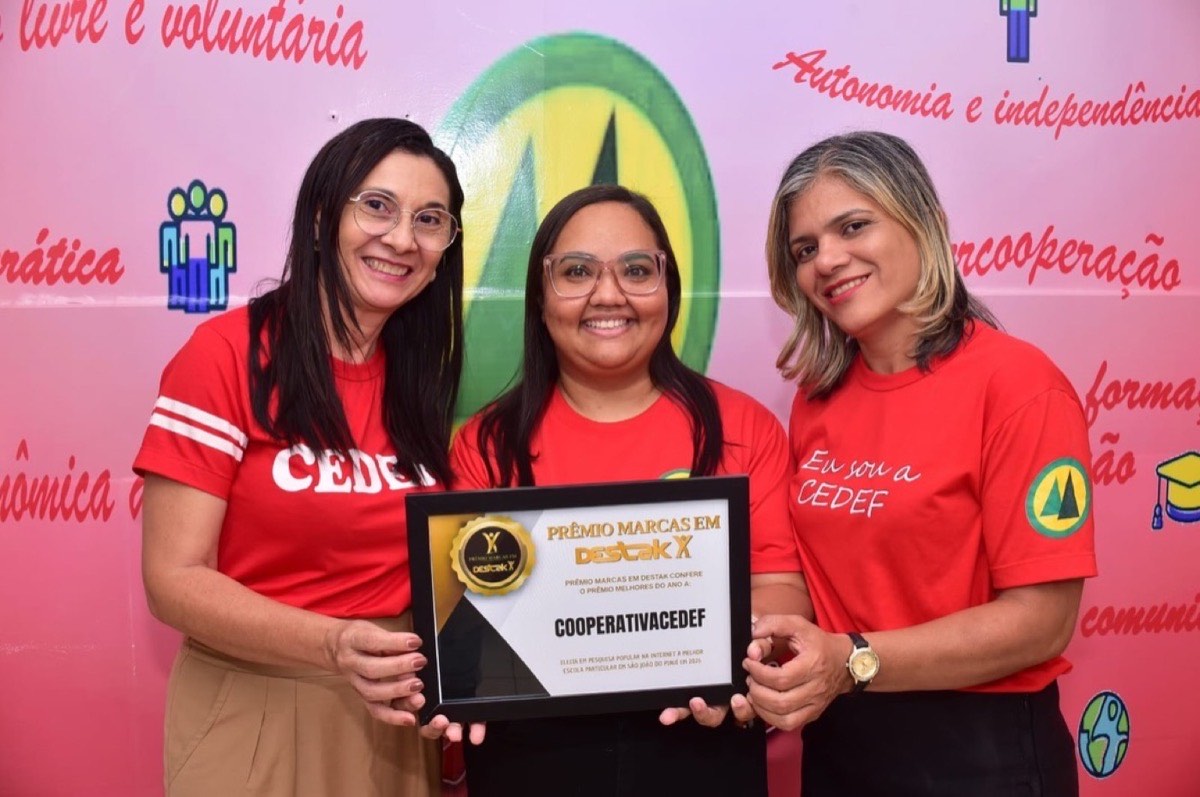 Equipe da CEDEF, de camisa vermelha da escola, segurando a placa do Prêmio Marcas em Destak